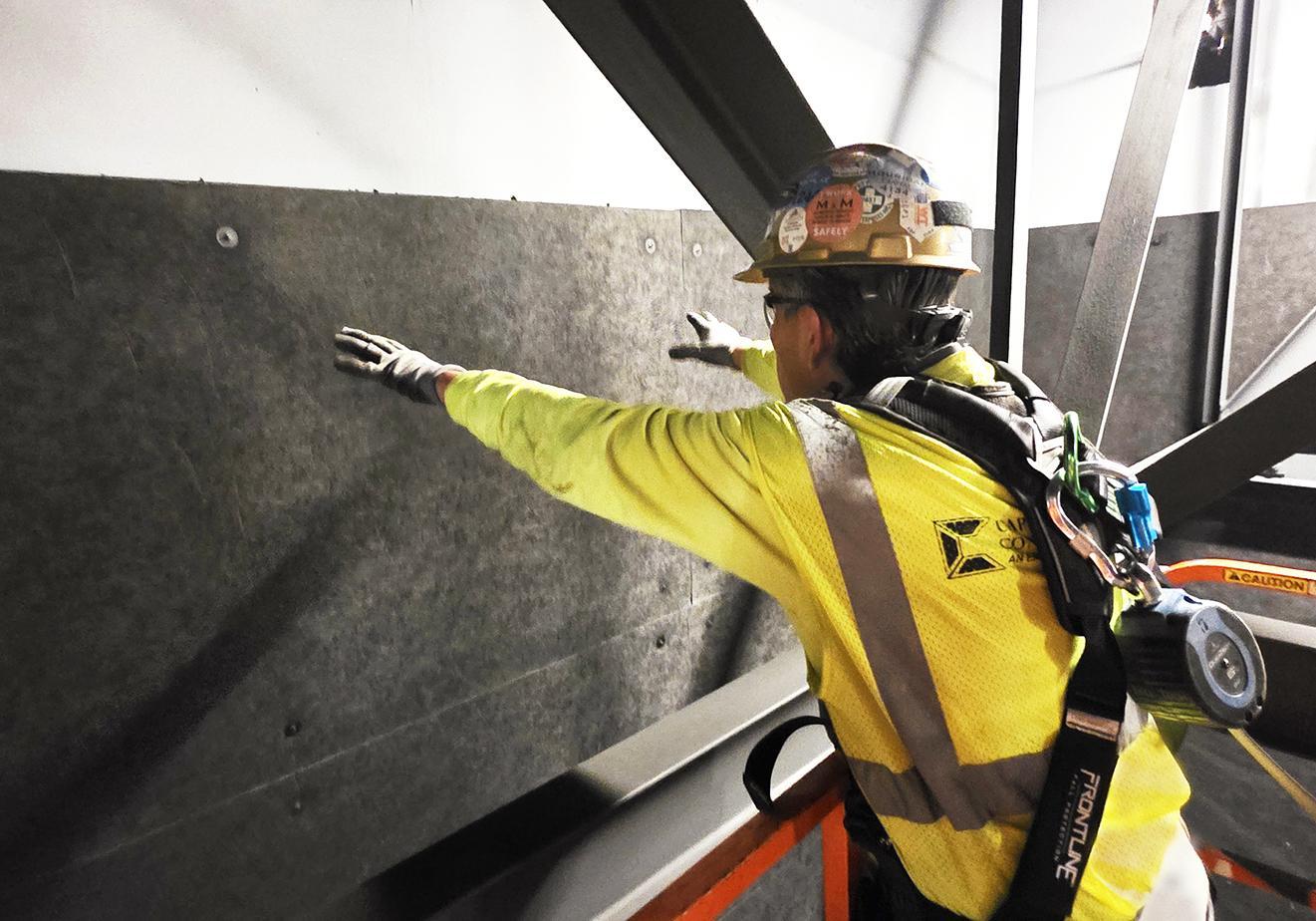 A contractor installing polyester acoustic panels into an office building.