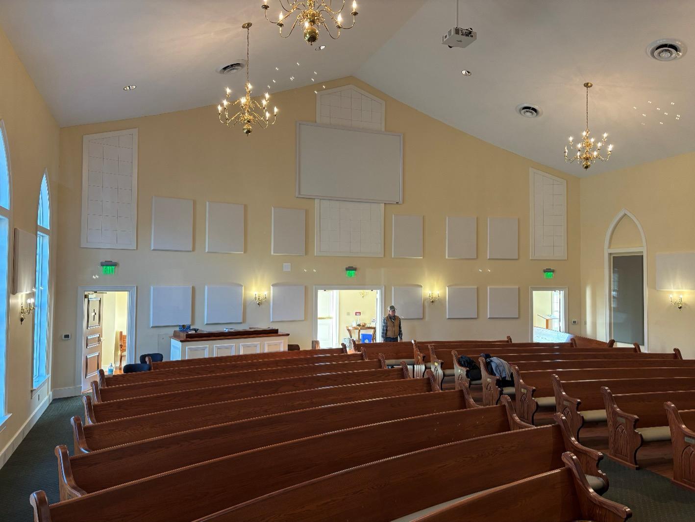 Fabric wrapped acoustic panels reduce echo in a church sanctuary.
