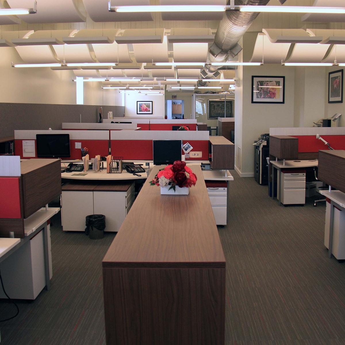 Open office plan using red AlphaSorb® panels and Sonex® Whisperwave® Clouds in ceiling.