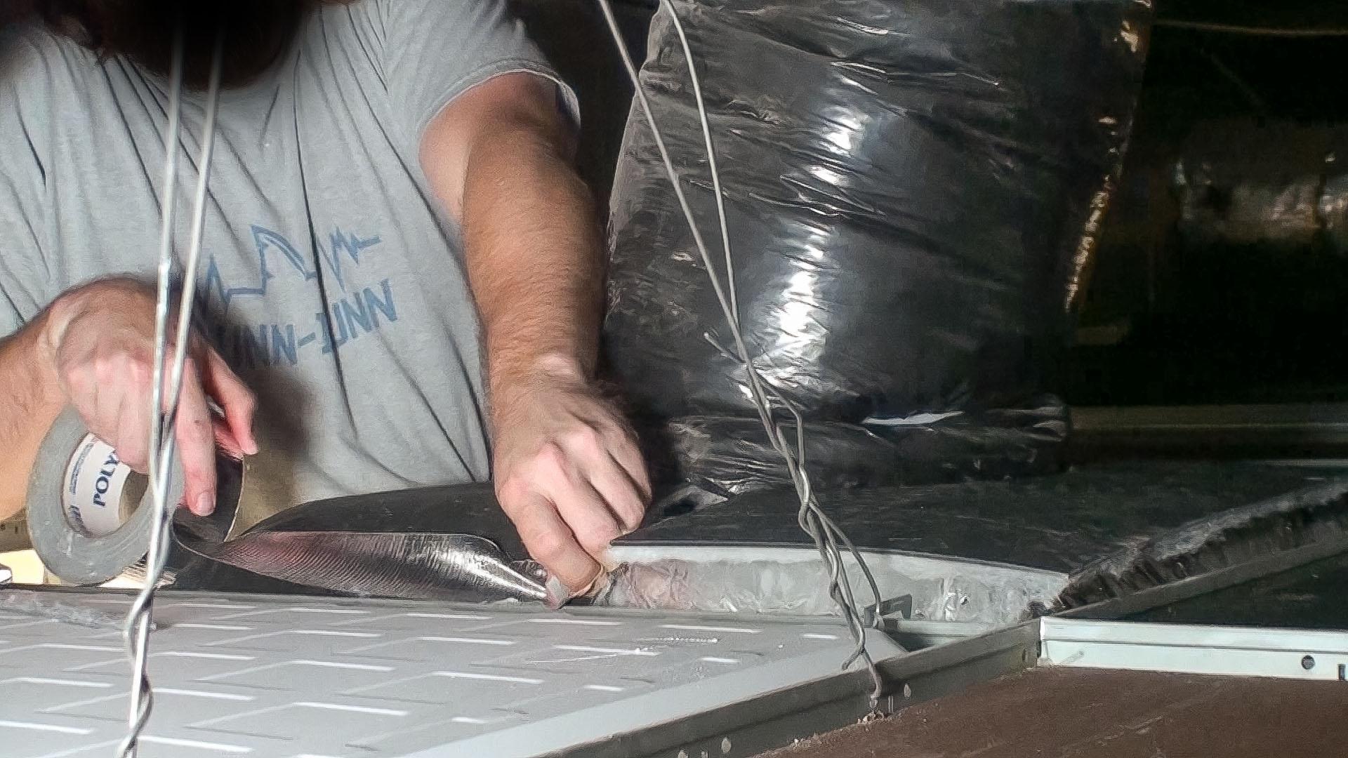 The Ceiling Tile Barrier is then cut in half and installed around ductwork, taping it down to eliminate air gaps