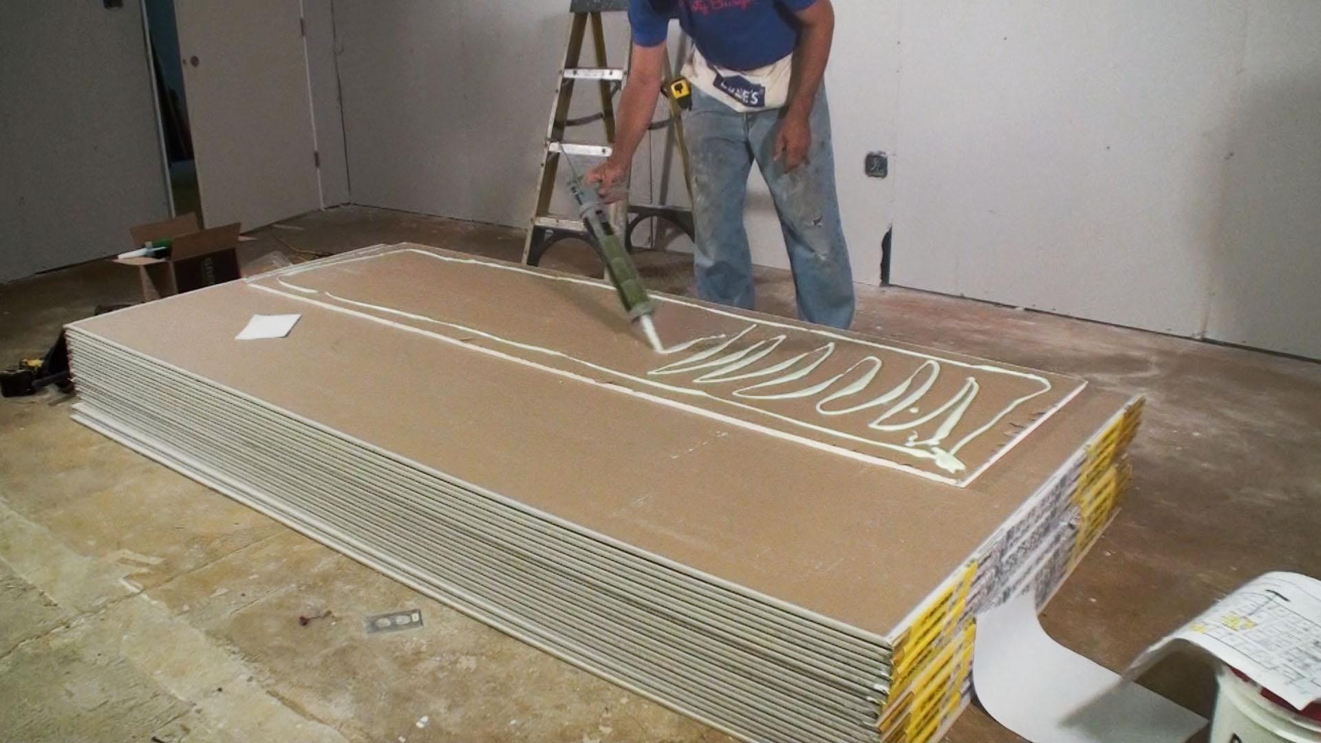 Green Glue is applied to the back of a second layer of drywall