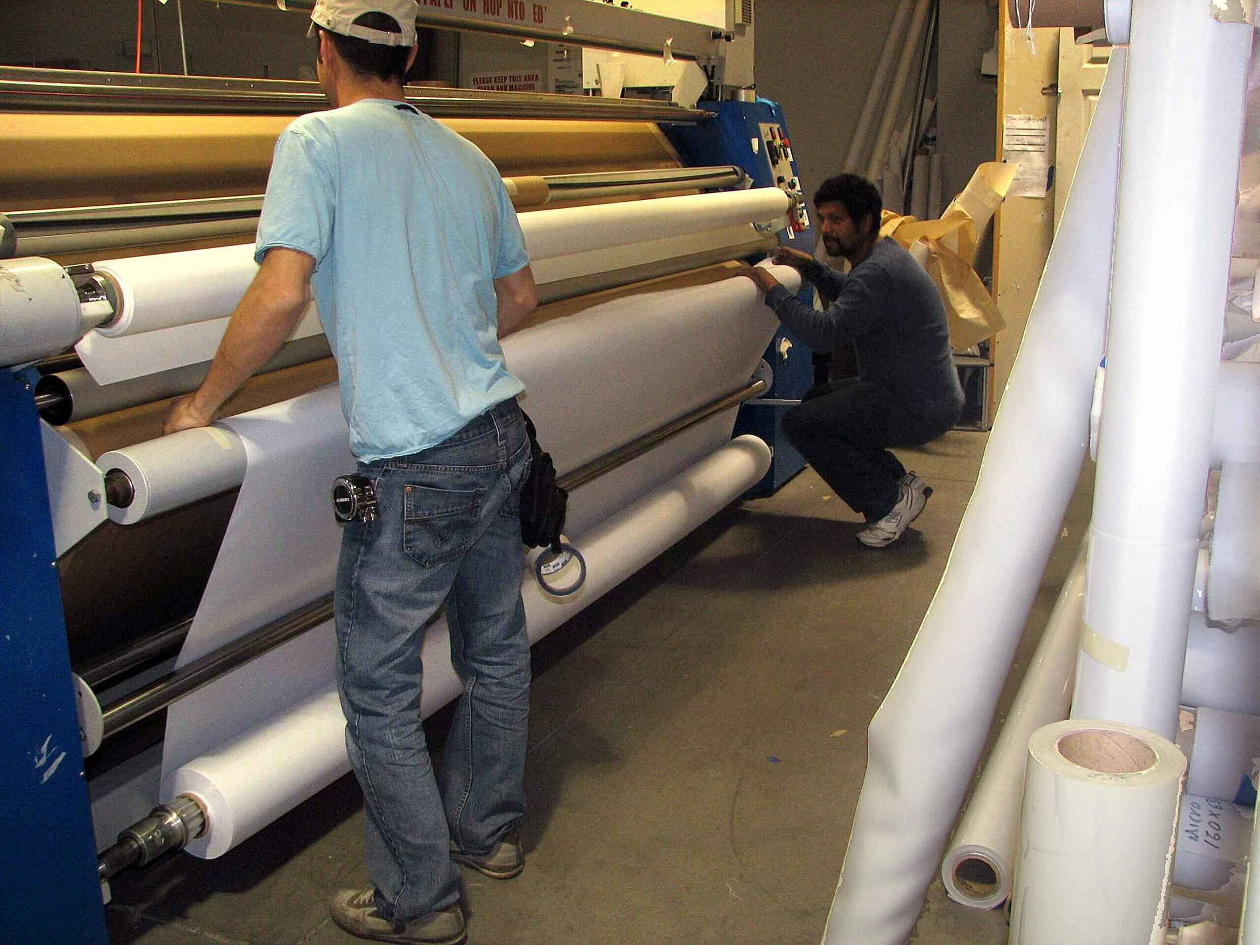 Printable fabric is webbed onto the press