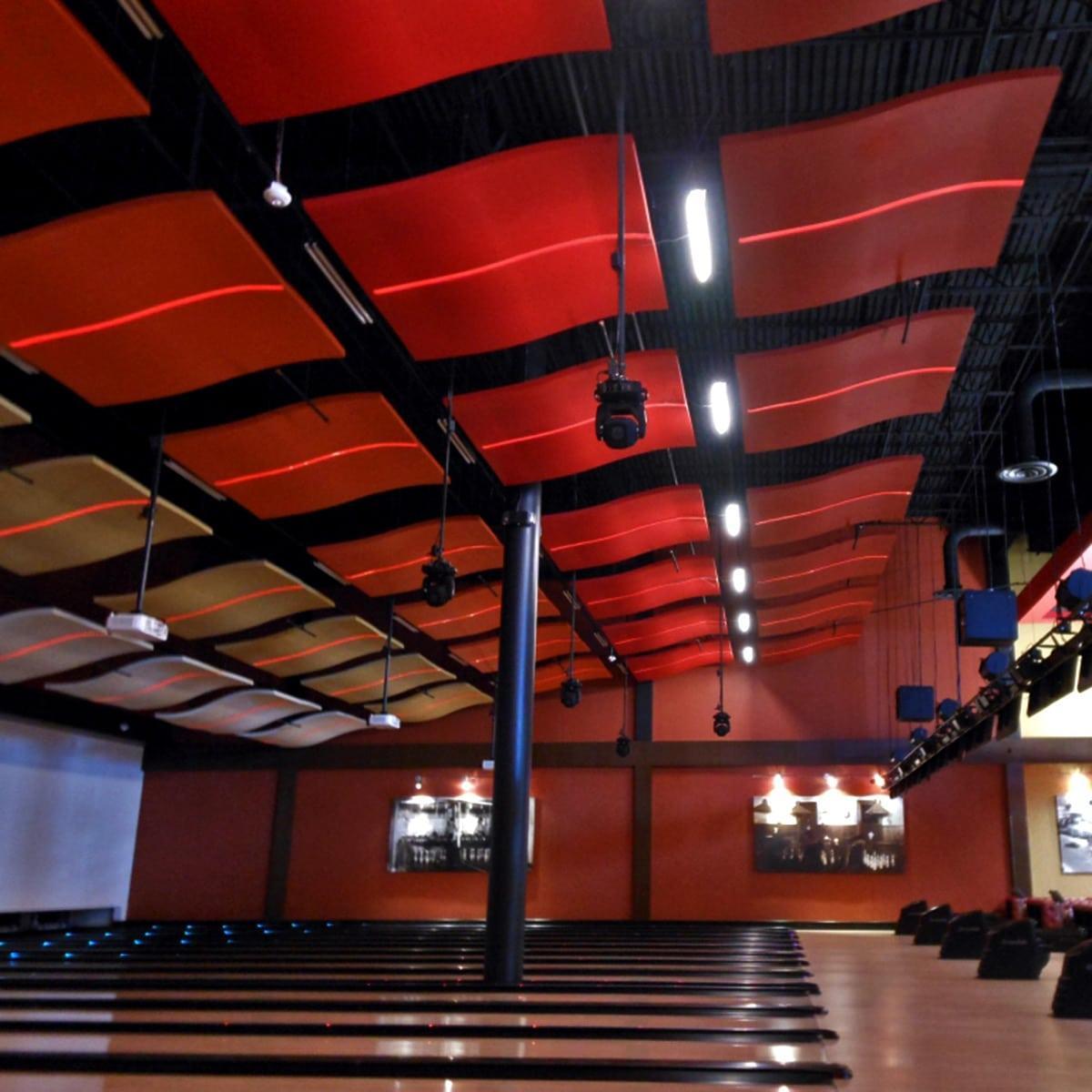 The Whisperwave® Clouds by Pinta Acoustic, Inc. in this application photo were customized to fit the design and theme of this this bowling alley theater.