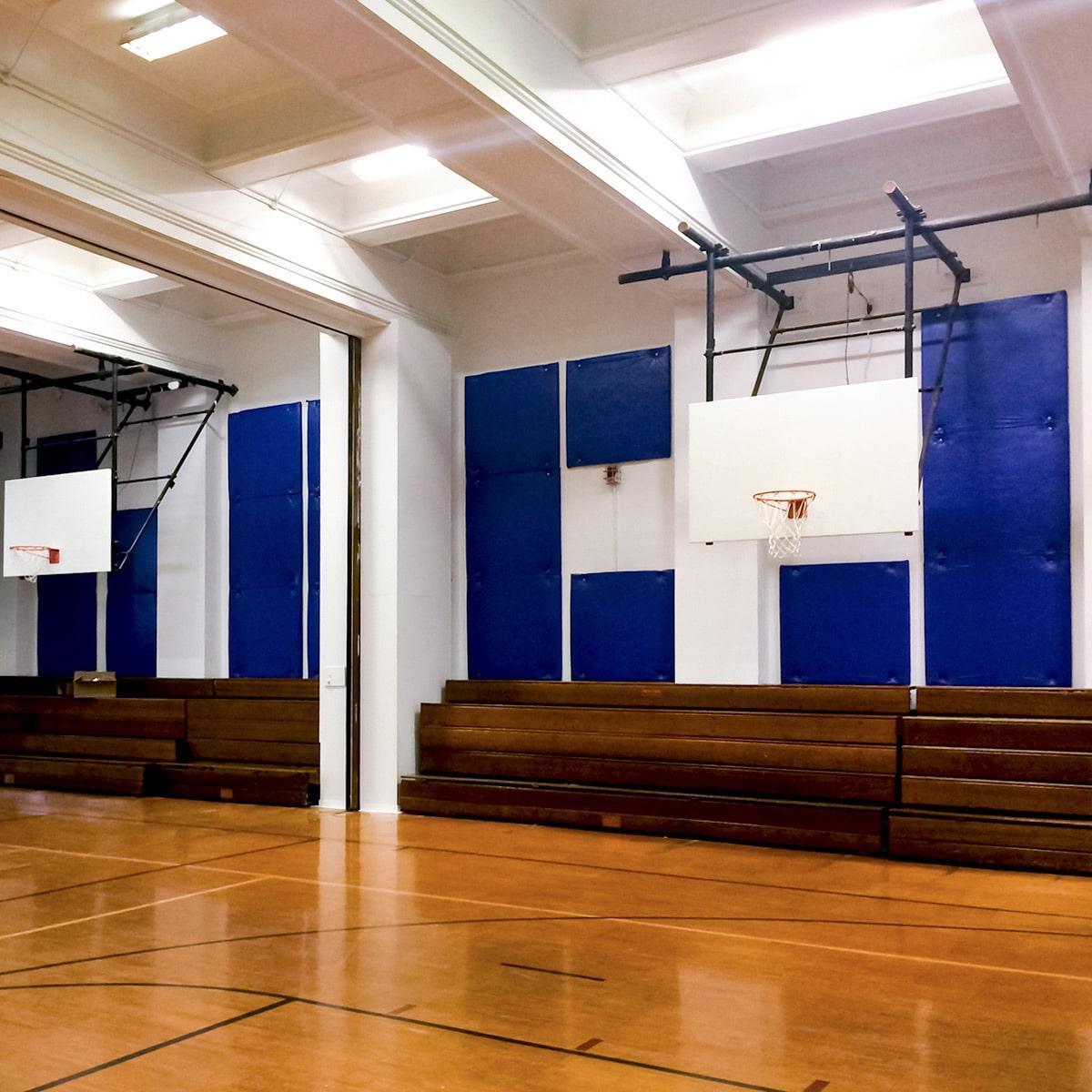 Plastic PCV baffles on the wall reduce sound in a school's gymnasium.