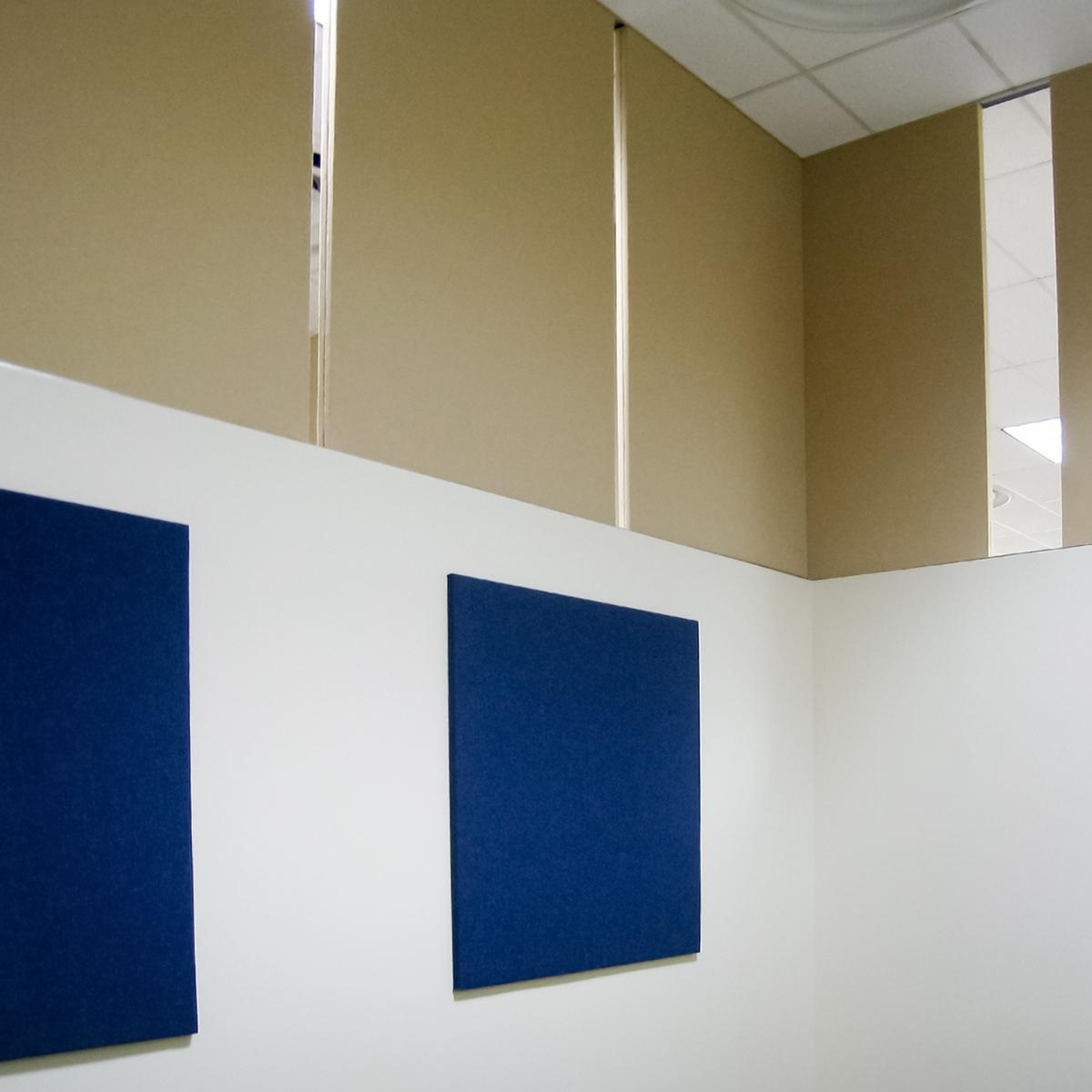 Acoustic panels installed on top of a partition wall to improve acoustics in a conference room space.