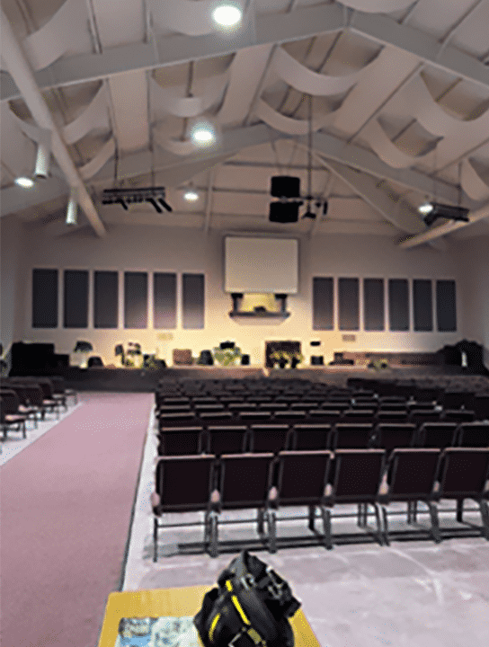 Fabric wrapped acoustic panels and ceiling banners improve speech intelligibility and reduce echo in a church. 