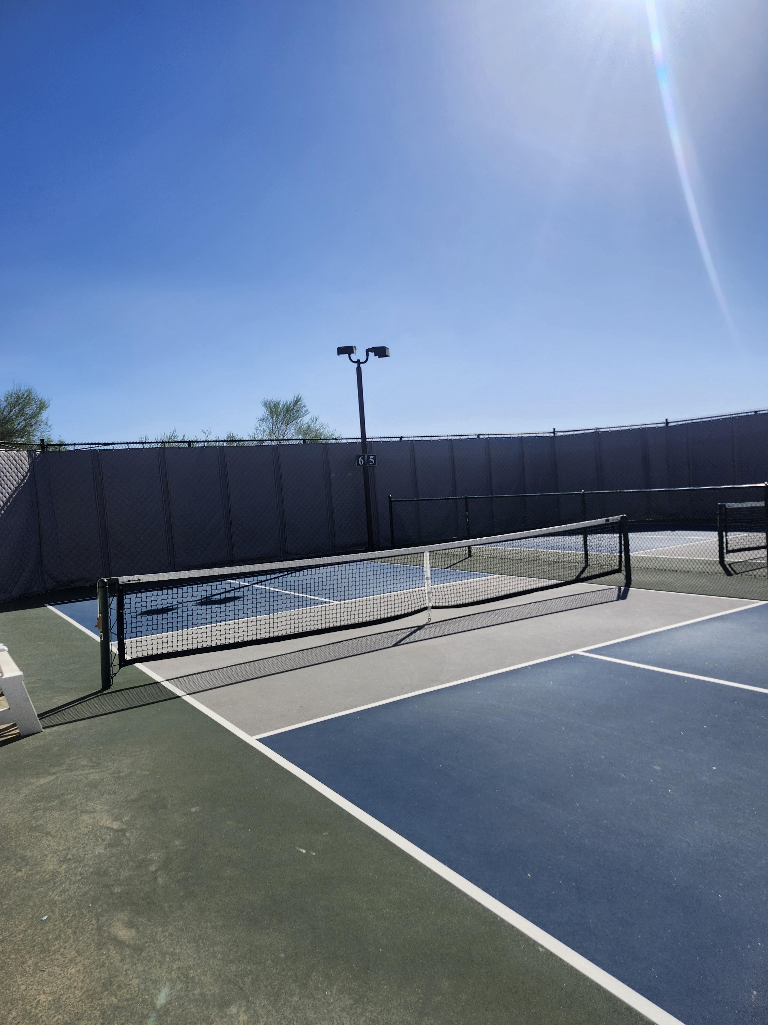 Acoustic blankets reduce noise in an outdoor pickleball court.