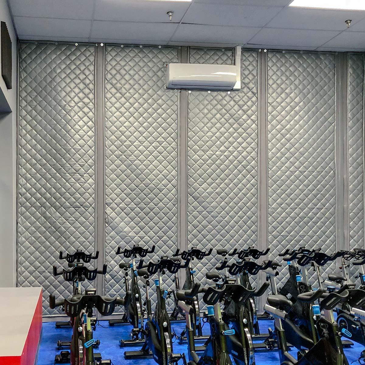 PrivacyShield® Absorptive Soundproofing Blankets  installed as a barrier to treat the acoustics in a spin cycle class room.