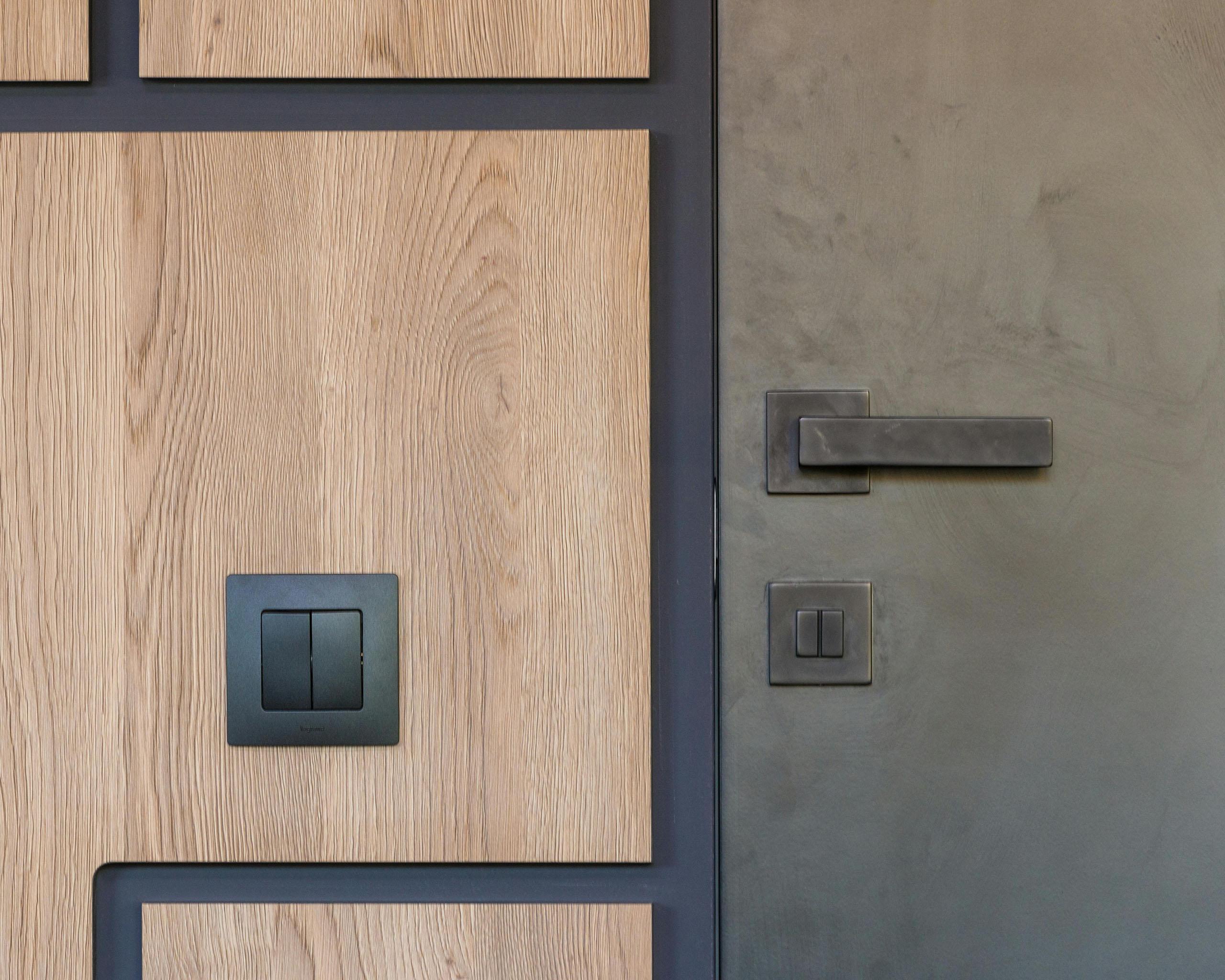 Photo of a modern wood and metal door frame and rocker light switch. Photo by Max Vakhtbovycn on Pexels.