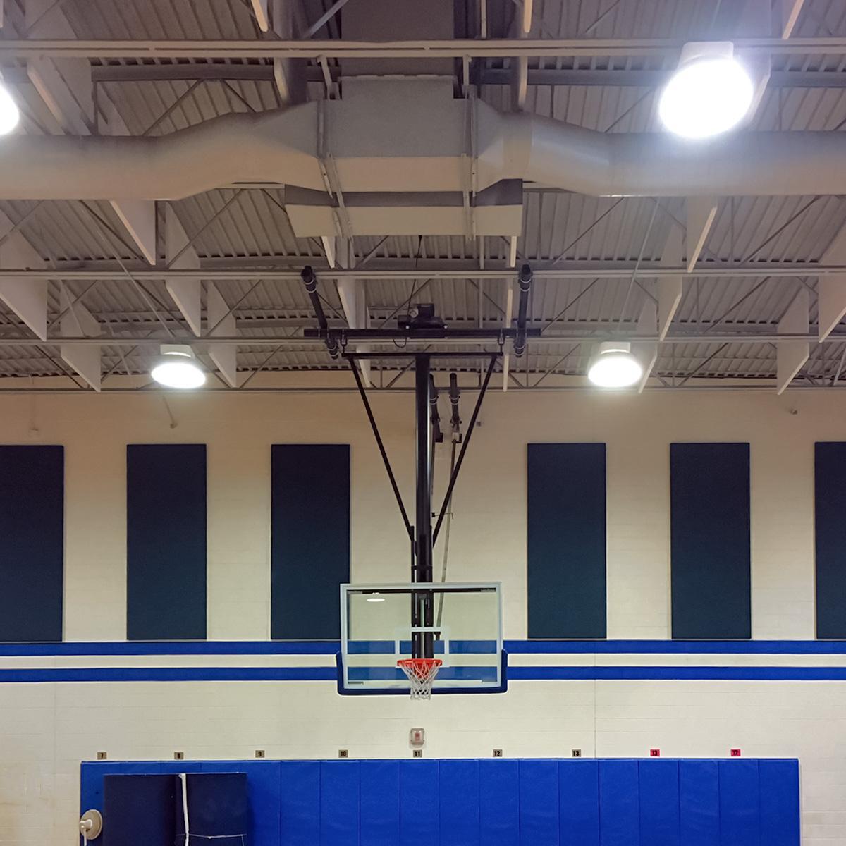Plastic acoustic baffles in the ceiling reduce echo and noise level in a school gymnasium.