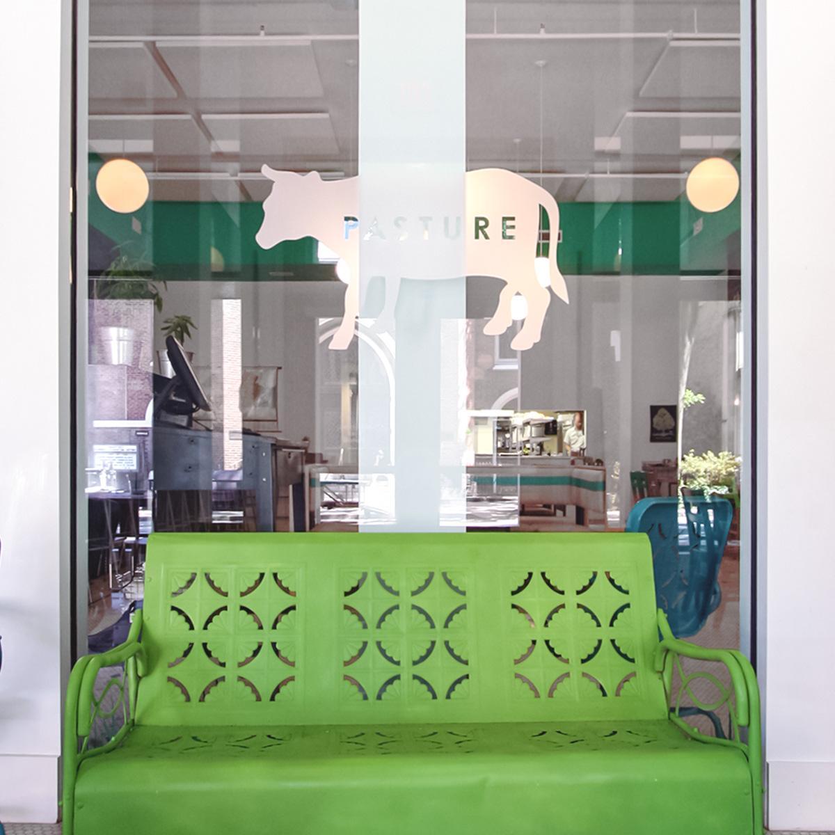 A window looking into Pasture, a restaurant that installed acoustic panels in the ceiling to reduce noise.