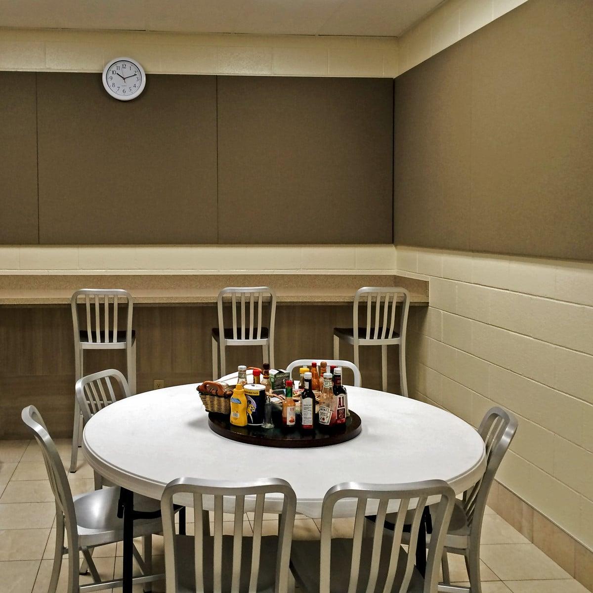 Fabric wrapped acoustic panels line the wall in an employee lounge to reduce echo.