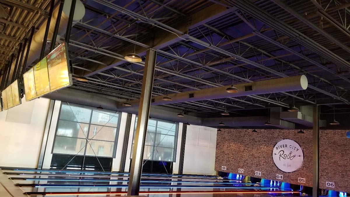 Bowling lane area with ceiling acoustic treatment