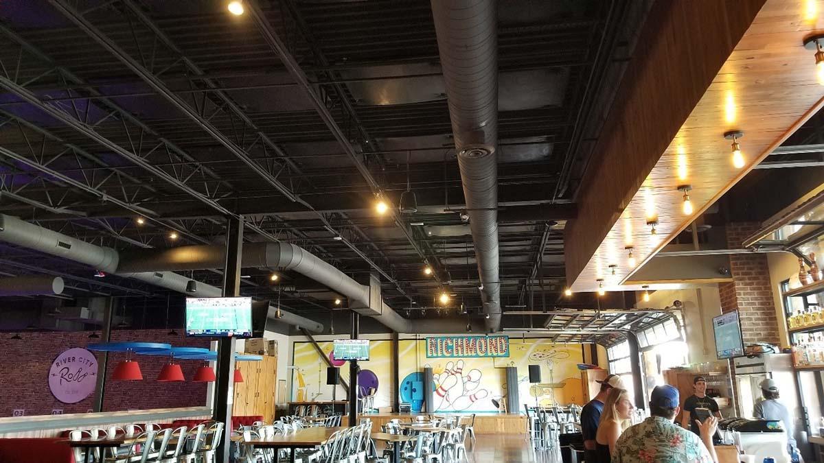 Bowling alley seating area with ceiling acoustic treatment