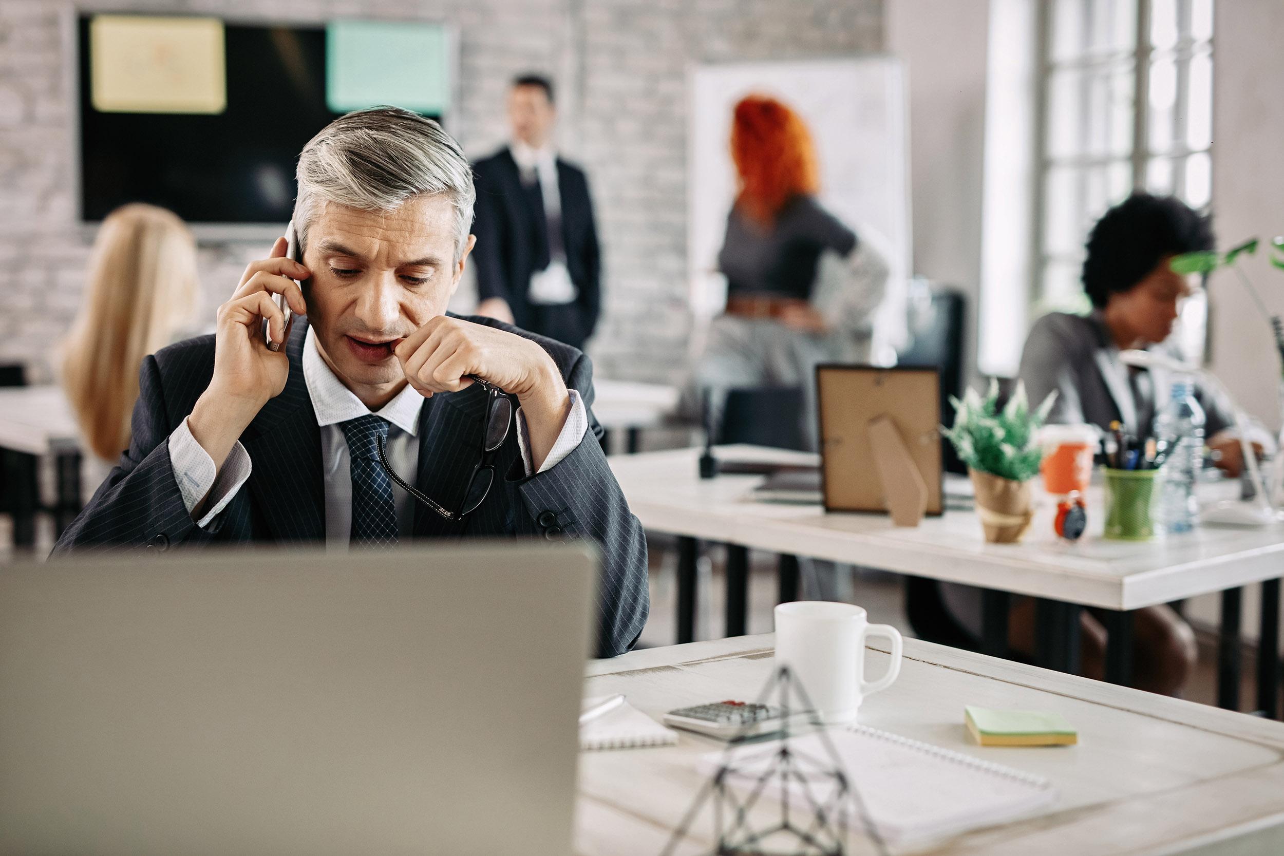 Man in noisy office trying to take a phone call. Image by Dragan Digic on Freepik