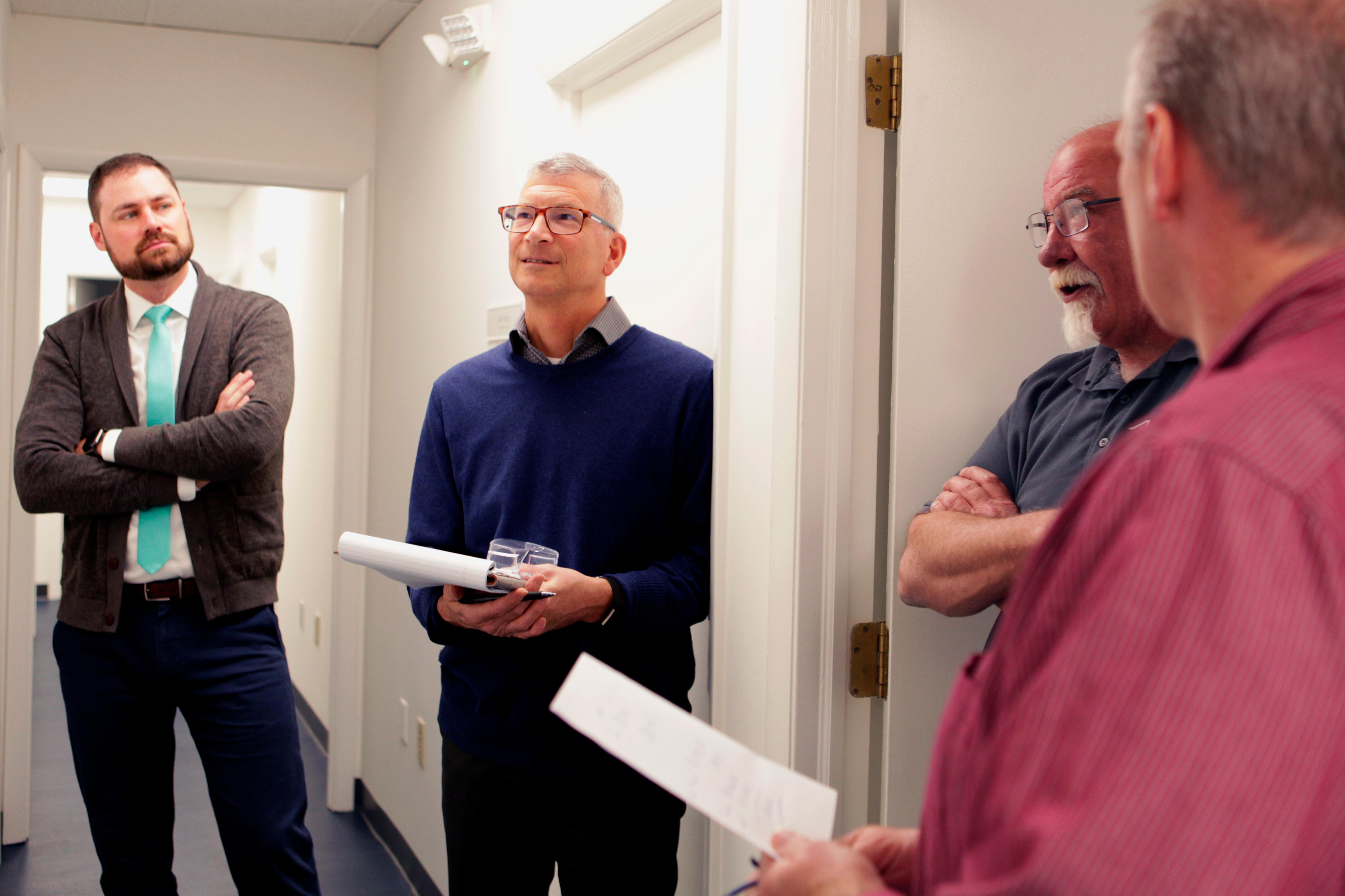 A group of employees talking in the Acoustical Solutions lobby.
