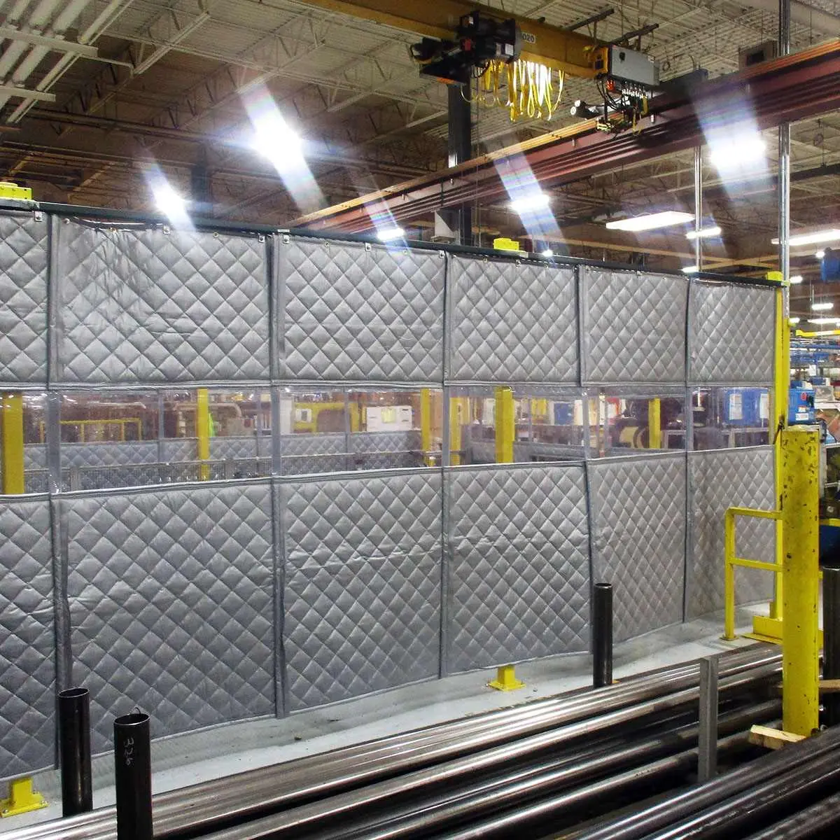 PrivacyShield® Dual-Sided Absorptive Soundproofing Blankets surround a TCO workcell to comply with OSHA standards