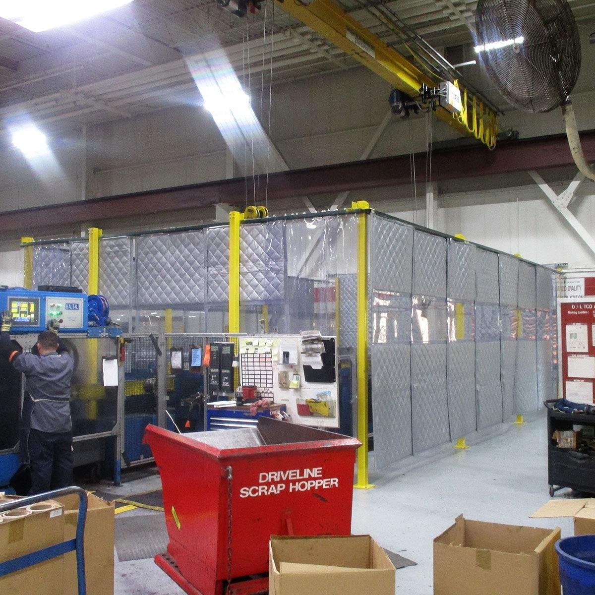 A custom blanket soundproof enclosure treats the acoustics in a workcell at an industrial plant.