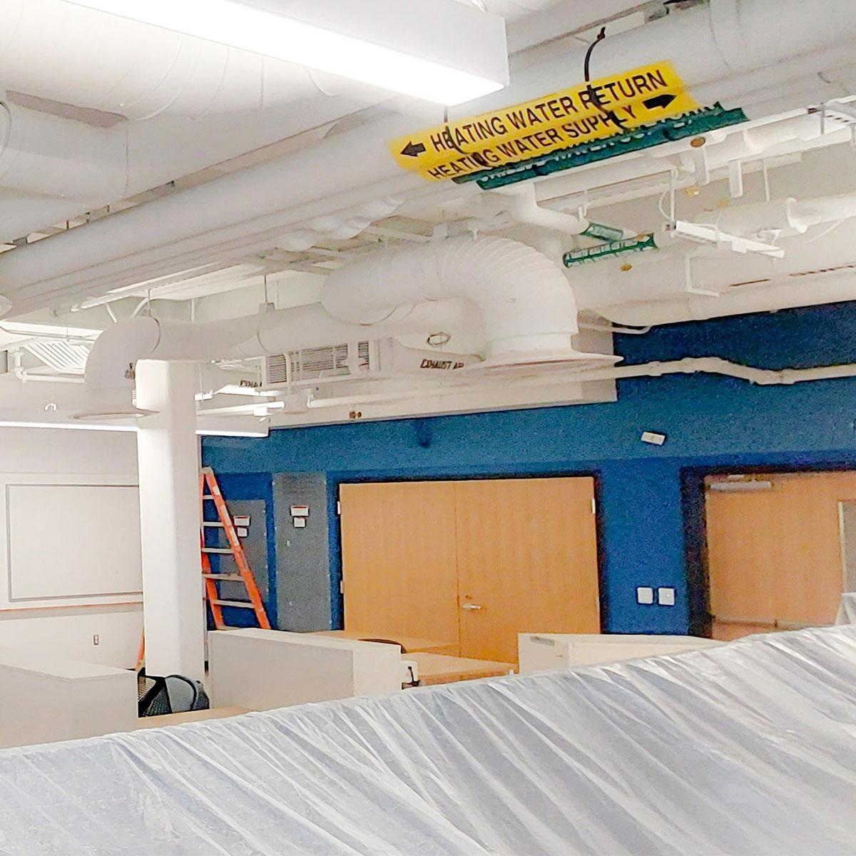 Blue Acoustic Felt Wall Panels above the doors and white panels above the whiteboards installed in the UVA Physics building