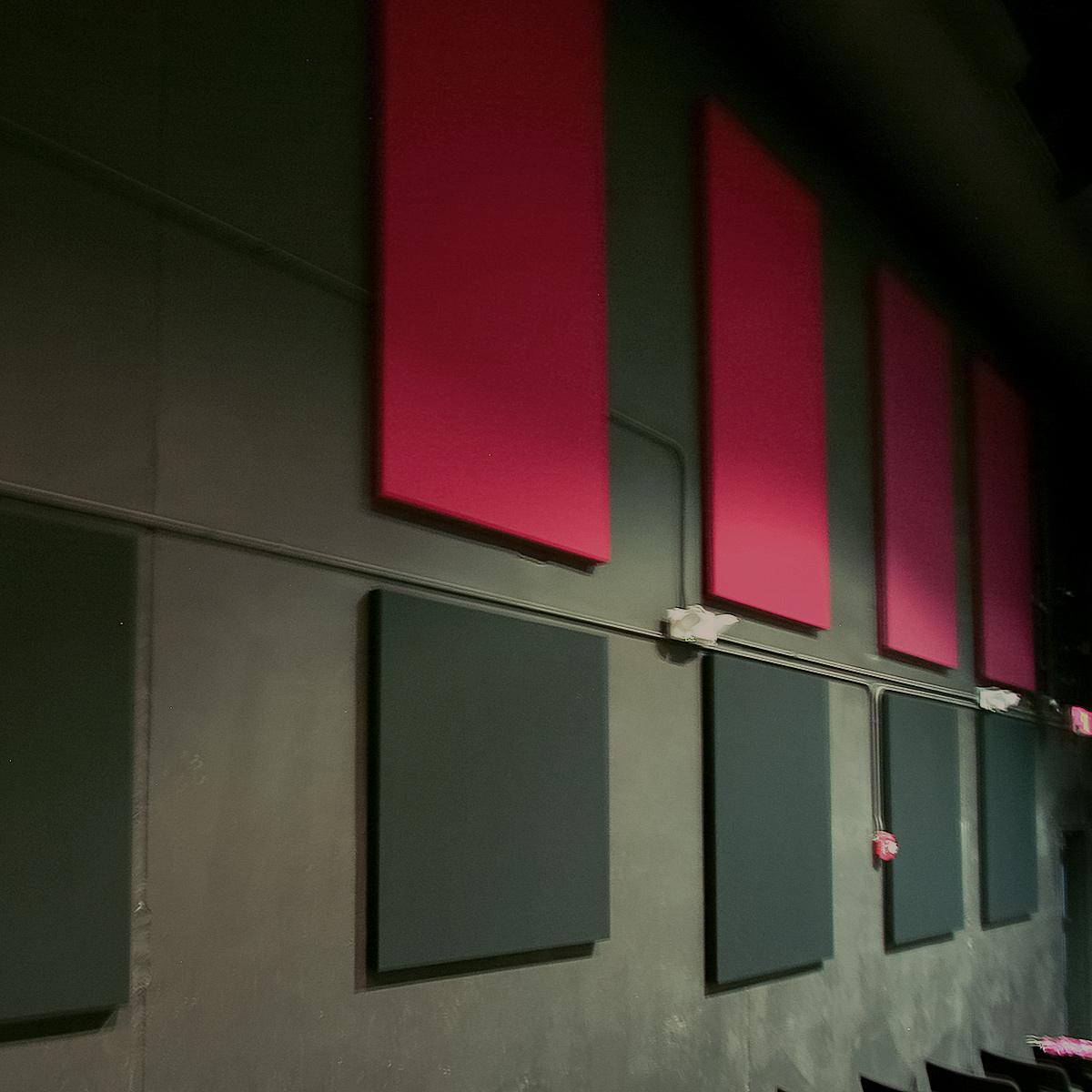 Fabric wrapped acoustic panels on the walls of a theater reduce echo.