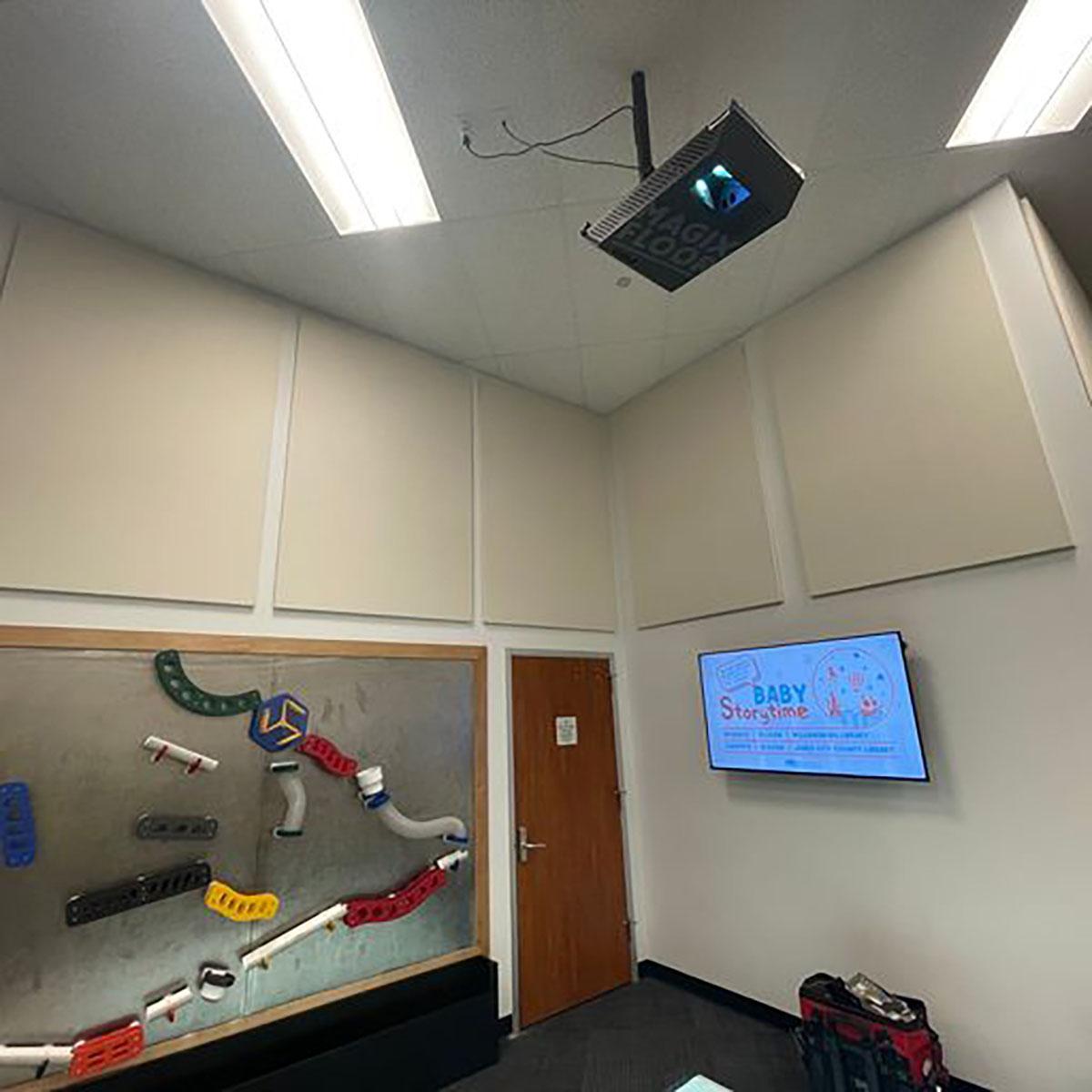 In the children's area of a library, fabric wrapped acoustic panels reduce reverberation in the space.