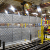 PrivacyShield® Dual-Sided Absorptive Soundproofing Blankets surround a TCO workcell to comply with OSHA standards